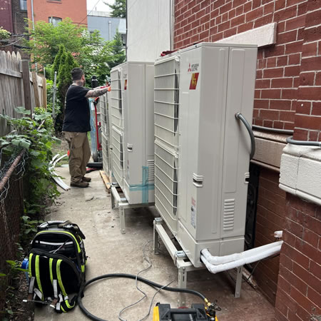 Hvac technician checking low refrigerant levels on a home air conditioner in merrick ny